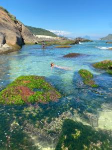 a person swimming in a body of water at Apartamento com vista e privacidade , ideal para casais , próximo da praia in Rio de Janeiro