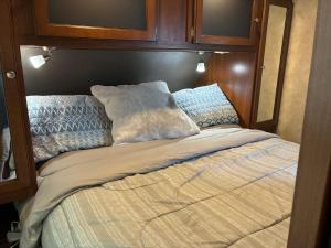 a bed in a room with a wooden wall at My Little RV Getaway in Pass Christian
