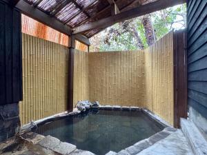 a swimming pool in a backyard with a wooden fence at Yufuin Ryokan Yufumomiji in Yufu