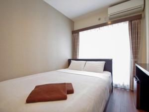 a bedroom with a large white bed with a large window at ホテルリブマックスBudget川崎大師 in Kawasaki