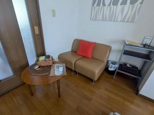 ein Wohnzimmer mit Sofa und Tisch in der Unterkunft Episode1 in Naoshima