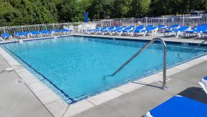 a large swimming pool with blue chairs and chairs at Put-in-Bay Condos in Put-in-Bay
