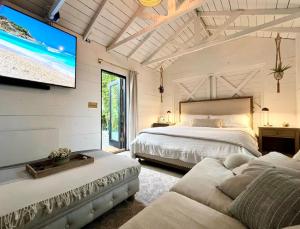 a bedroom with two beds and a flat screen tv at NiDOMARE - Channel Islands Beach Retreat in Oxnard