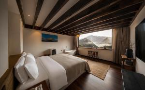 a bedroom with a large bed and a large window at NINE PEAKS in Jiuzhaigou