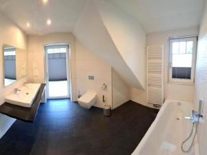 a large bathroom with a sink and a tub and a tub at Ferienhaus Strandnah - Ostseeurlaub in Glowe in Top-Lage in Glowe +28 photos