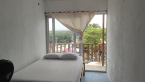 a bed in a room with a large window at La Casa de la Tortuga in San Onofre