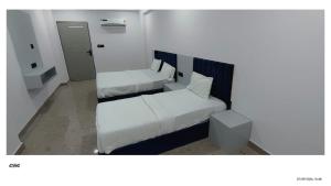 a small bedroom with two beds and a mirror at Hotel Venue in Ellis Bridge