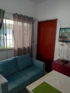 a living room with a blue couch and a red door at Casa no centro - perto de tudo in Itaguaí