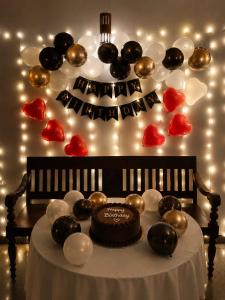 a table with a cake and balloons on a wall at Getaway Beach Resort Kovalam in Kovalam +78 photos