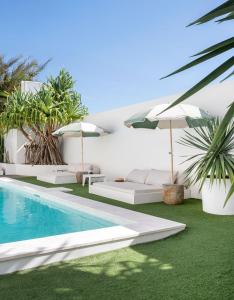 a villa with a swimming pool and umbrellas at Crystal Pacific Palm Beach in Gold Coast