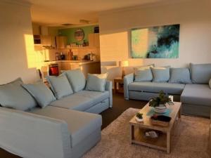 a living room with two couches and a table at Ocean Views in Rockingham