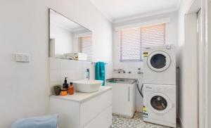 a white bathroom with a washing machine and a washer at Ocean Views in Rockingham