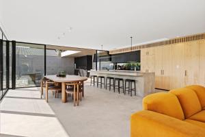 an open kitchen and dining room with a table and chairs at Betula in Tilba Tilba