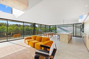 an open living room with a couch and a table at Betula in Tilba Tilba