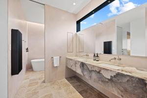 a bathroom with two sinks and a large window at Betula in Tilba Tilba +19 photos