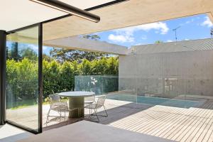 a patio with a table and chairs and a pool at Betula in Tilba Tilba
