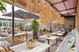 a restaurant with tables and chairs and chandeliers at INNSiDE by Meliá Barcelona Apolo in Barcelona