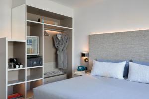 a bedroom with a bed and a dress hanging on a shelf at INNSiDE by Meliá Barcelona Apolo in Barcelona