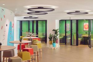 a restaurant with colorful chairs and tables in a cafeteria at INNSiDE by Meliá Barcelona Apolo in Barcelona