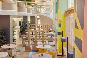 a restaurant with tables and chairs and a staircase at INNSiDE by Meliá Barcelona Apolo in Barcelona