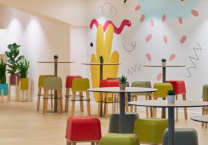 a restaurant with tables and colorful chairs at INNSiDE by Meliá Barcelona Apolo in Barcelona +67 photos