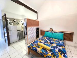 a bedroom with a bed with a kitchen in the background at SERENITY piscine 53m cube in La Trinité