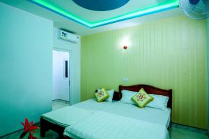 a bedroom with a bed with yellow pillows on it at Phuc Hau Hotel - Ly Son in Ly Son +10 photos