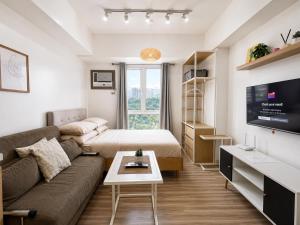 a living room with a couch and a bed at Cozy Condo at Avida Tower 4, IT Park Cebu in Cebu City