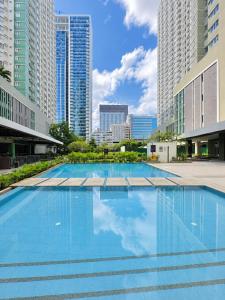 a large swimming pool in a city with tall buildings at Cozy Condo at Avida Tower 4, IT Park Cebu in Cebu City