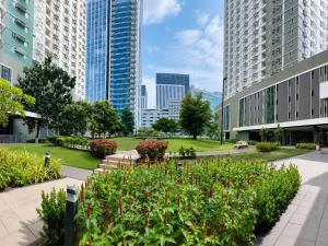 a garden in the middle of a city with tall buildings at Cozy Condo at Avida Tower 4, IT Park Cebu in Cebu City