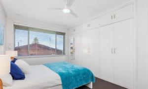 a white bedroom with a bed and a window at Ocean Views in Rockingham