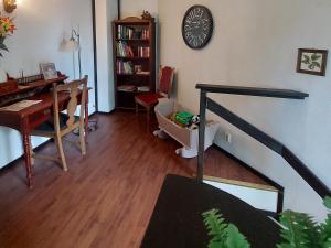a living room with a desk and a clock on the wall at Cronin's Guesthouse Bed & Breakfast in Heinola