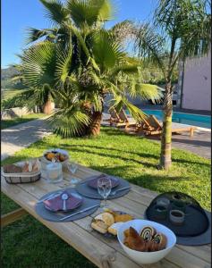 a wooden table with food on it with palm trees at Préfacio Do Silêncio in Godinhaços