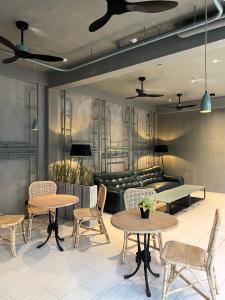 a room with tables and chairs and a couch at Grids by Epic Collection in Unawatuna
