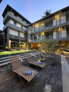 a hotel with two lounge chairs and a building at Grids by Epic Collection in Unawatuna