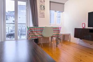 een woonkamer met een tafel en stoelen en een balkon bij Apartamento Mártires da Pátria in Lissabon