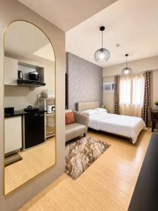 a hotel room with a bed and a mirror at MIGAs Haven at Sunvida Tower across SM City in Cebu City