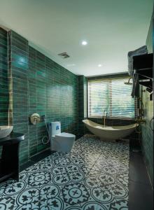 a bathroom with a tub and a toilet and a sink at De Mémoire Retreat in Tien Xuan +66 photos