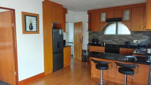 a kitchen with wooden cabinets and black appliances at Executive Sea View Apartment in Glencairn