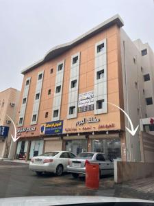 a large building with cars parked in front of it at Luxury Smart Entry Studio in Buraydah