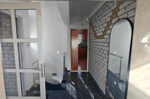 a bathroom with a mirror and a brick wall at Executive Sea View Apartment in Glencairn