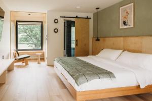 a bedroom with a large bed and a bathroom at Otherland Hotel in Newfane