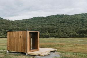 a tiny house sitting in the middle of a field at Otherland Hotel in Newfane