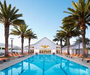 a swimming pool with palm trees and a building at Carneros Resort and Spa in Napa