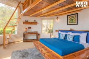 a bedroom with a blue bed and a fireplace at StayVista at Sukoon Nature Retreat in Bhatrojkhan