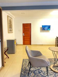 a living room with a chair and a table at Peach City Hotel in Prampram