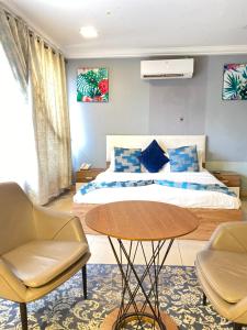 a bedroom with a bed and a table and chairs at Peach City Hotel in Prampram +26 photos