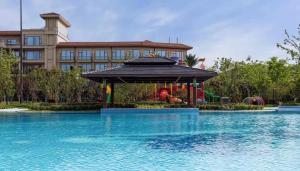a swimming pool with a gazebo in front of a building at Crowne Plaza Huzhou by IHG in Huzhou