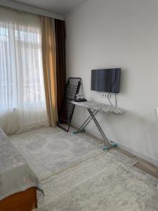 a room with a tv and a table and a chair at Квартира студия in Bosteri