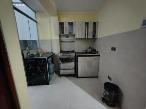a small kitchen with a sink and a stove at Esencia de Altura Hostal in El Tambo